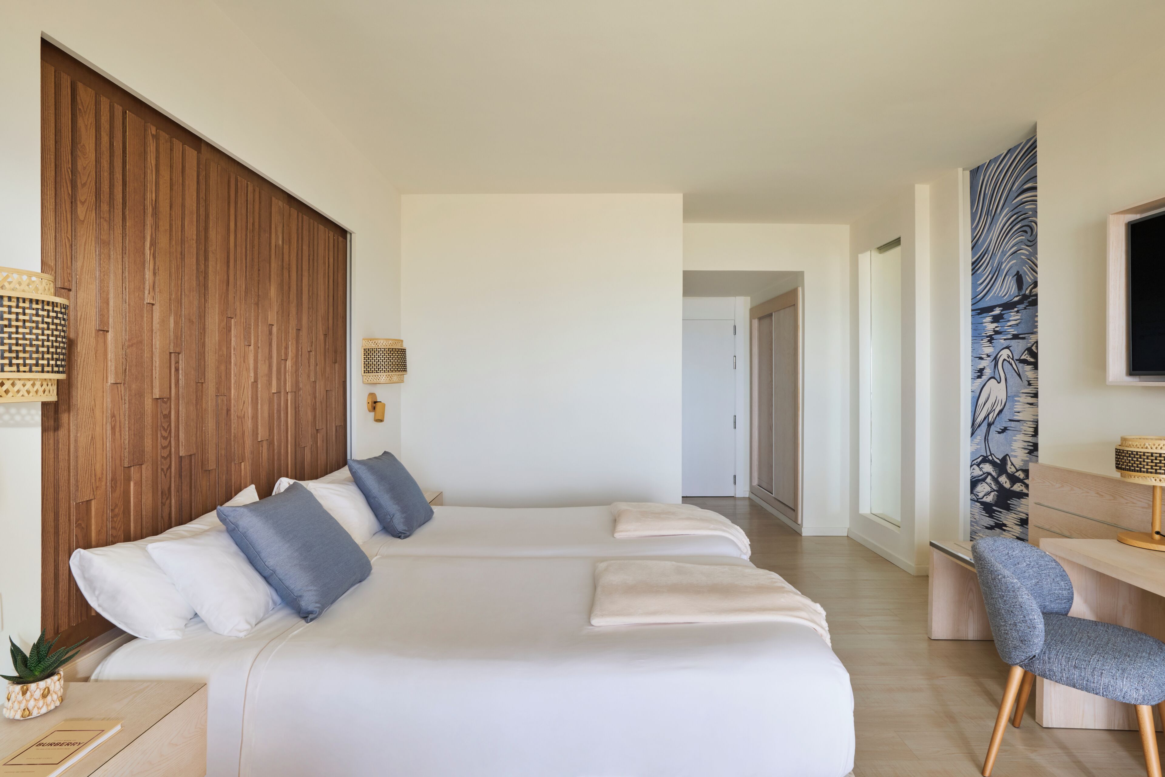 Ein modernes Hotelzimmer mit einem großen Bett, einem Schreibtisch und einem Stuhl.