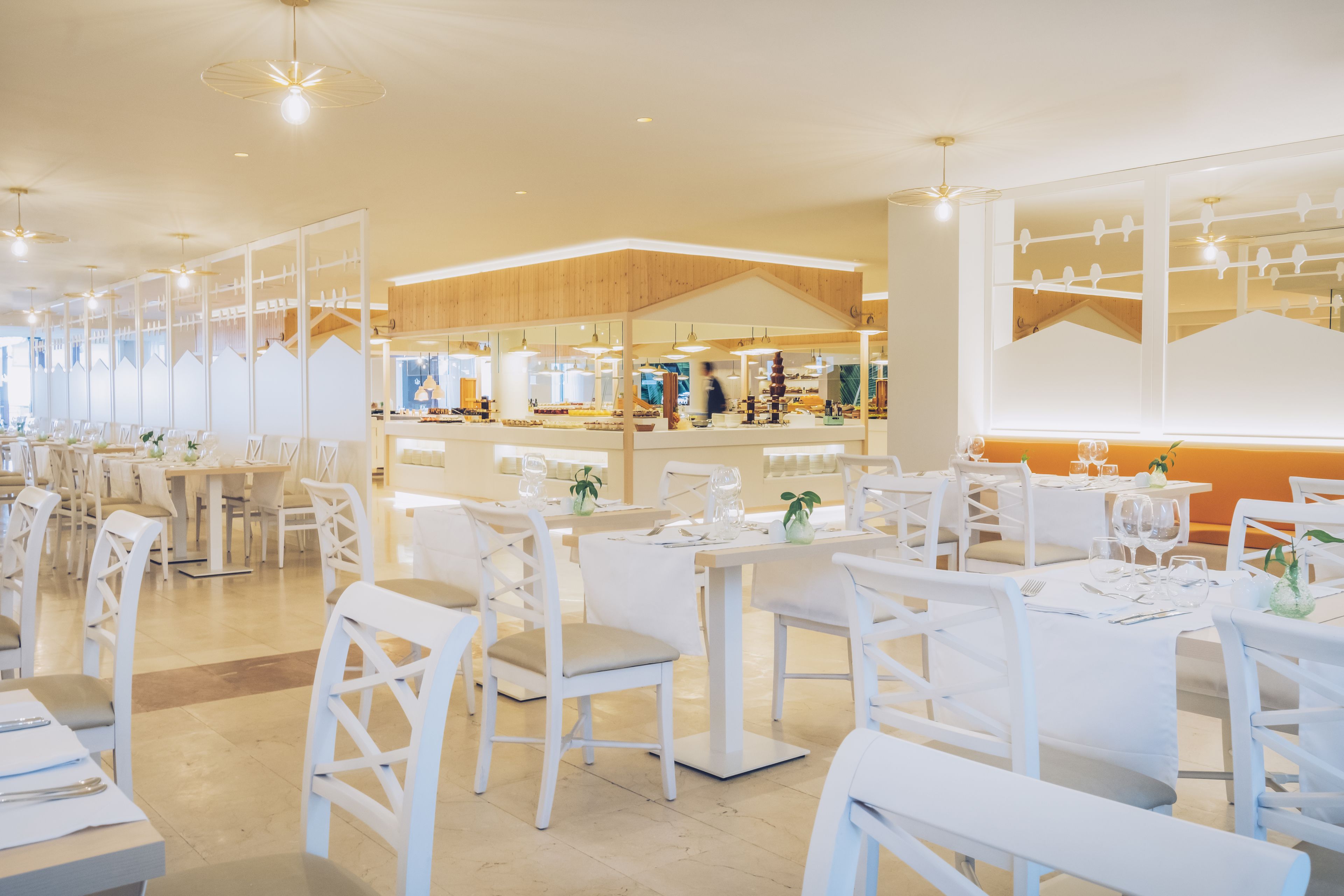 En rymlig restaurang med vita möbler och en modern inredning.