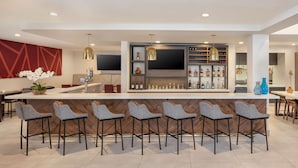 A modern kitchen with a central island, bar area, and seating. - Hilton Garden Inn Miami Airport West (Miami)