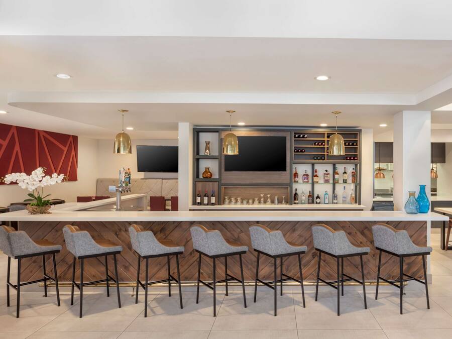 A modern kitchen with a central island, bar area, and seating.