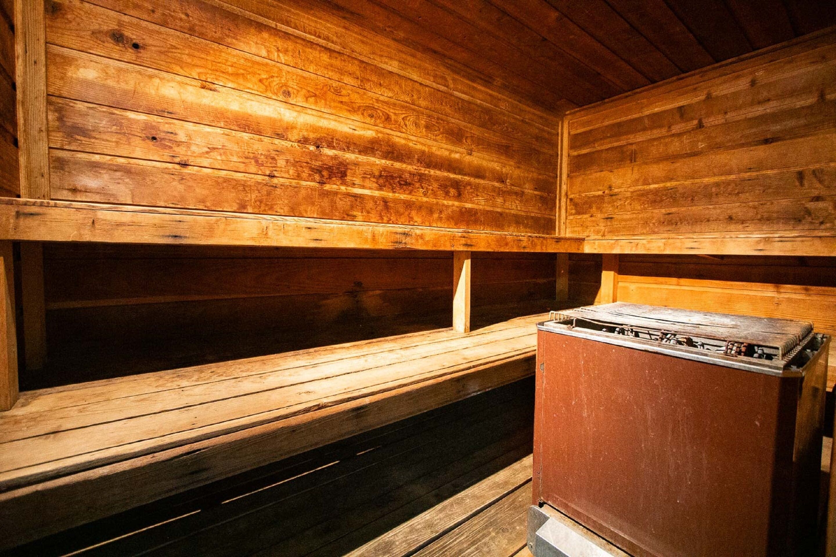 Een sauna met houten banken en een kast.