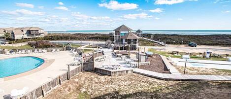 Une propriété située en bord de mer, dotée d’une piscine, d’un espace salon extérieur et d’un belvédère offrant une vue sur l’océan.