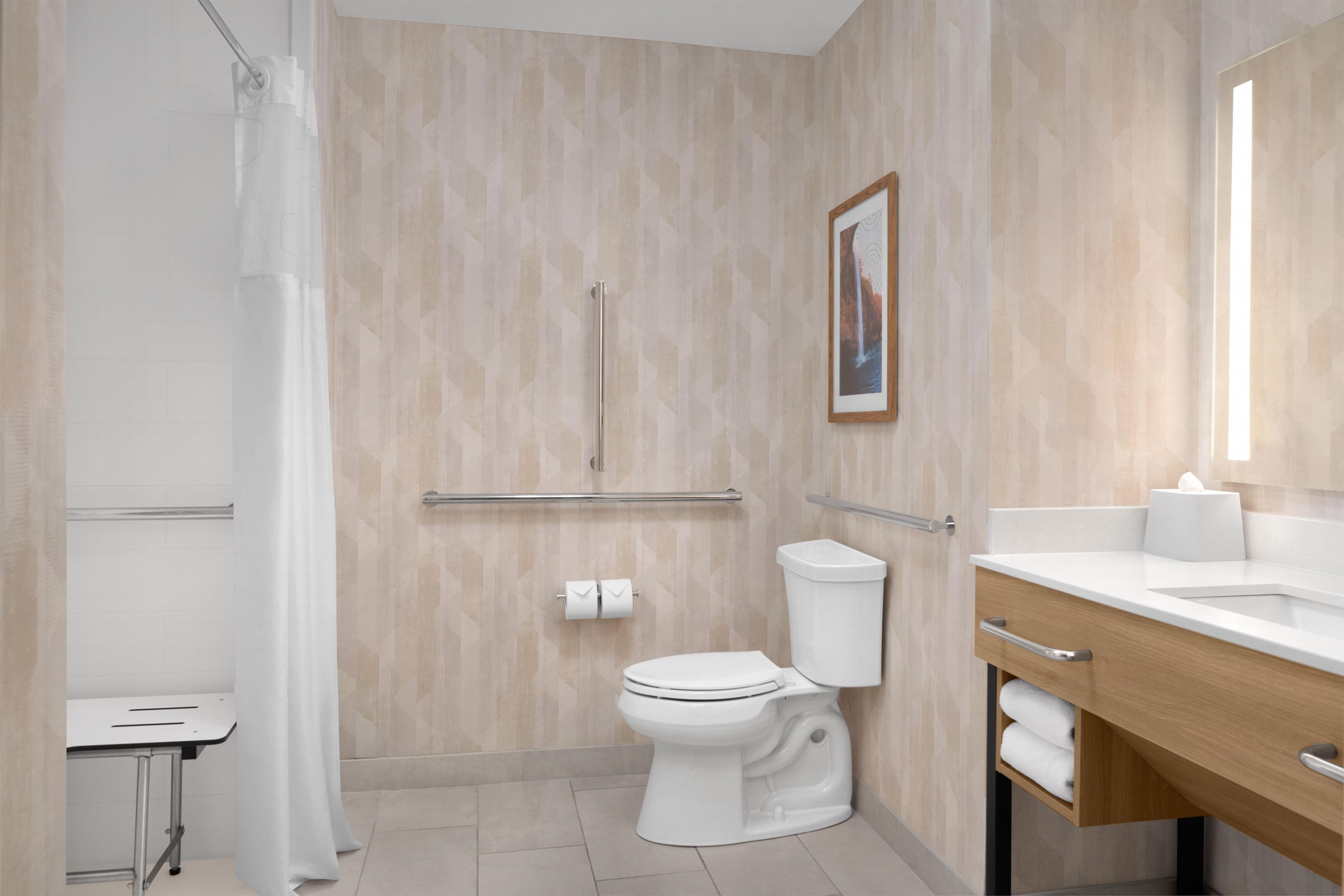 A modern bathroom with a toilet, sink, and shower area.