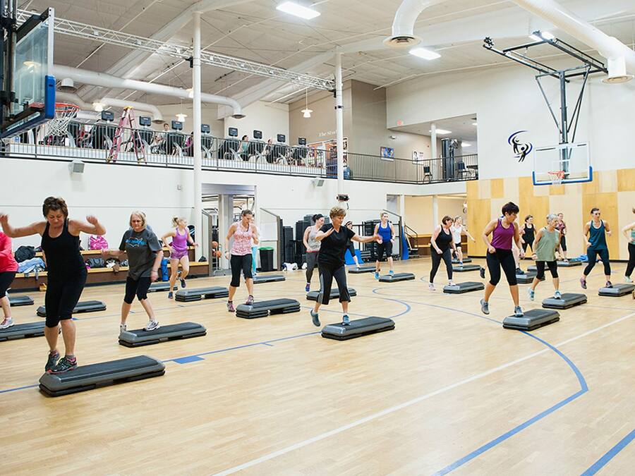 Un gimnasio con cancha de baloncesto y pared de escalada.