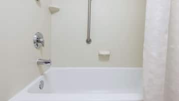 Bañera blanca estándar con ducha de mano y barra de apoyo.