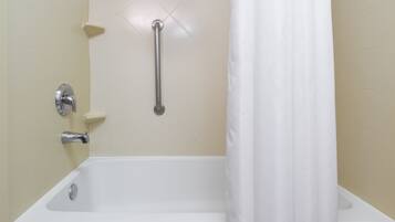 A standard bathroom with a bathtub, a shower curtain, and a grab bar.