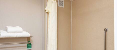 A bathroom with a toilet, a bathtub, a shower, and a towel rack.