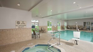 Piscina interior con hidromasaje, sillas de descanso y un cartel que indica prohibido bucear y sin salvavidas.
