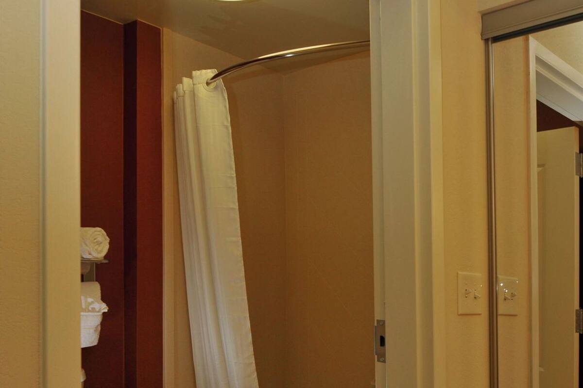 A bathroom with a bathtub, toilet, and shower curtain.