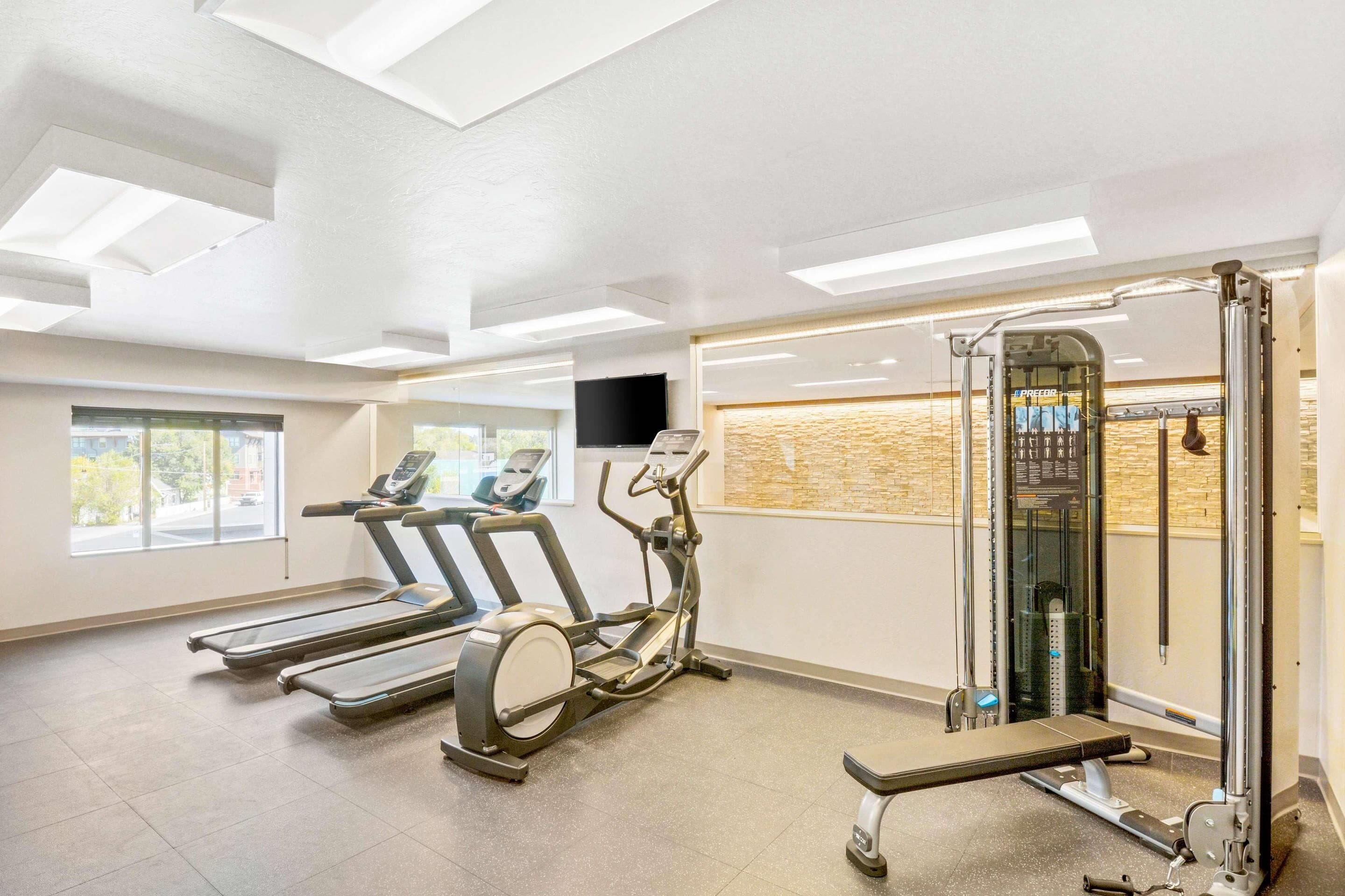 A gym with treadmills, an elliptical, and a weight machine.