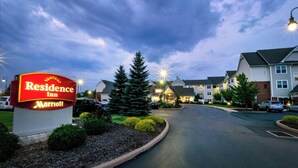 Une enseigne d’un hôtel Marriott Residence Inn, un parking et une rangée d’immeubles d’habitation.
