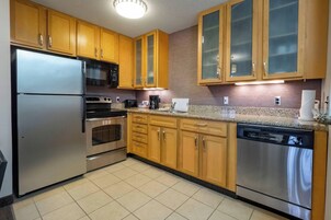 Una cocina con armarios de madera, electrodomésticos de acero inoxidable y encimera de granito.
