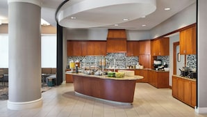 A modern kitchen with a central island, wooden cabinets, and a curved ceiling design. - Residence Inn National Harbor Washington, DC Area (Oxon Hill)