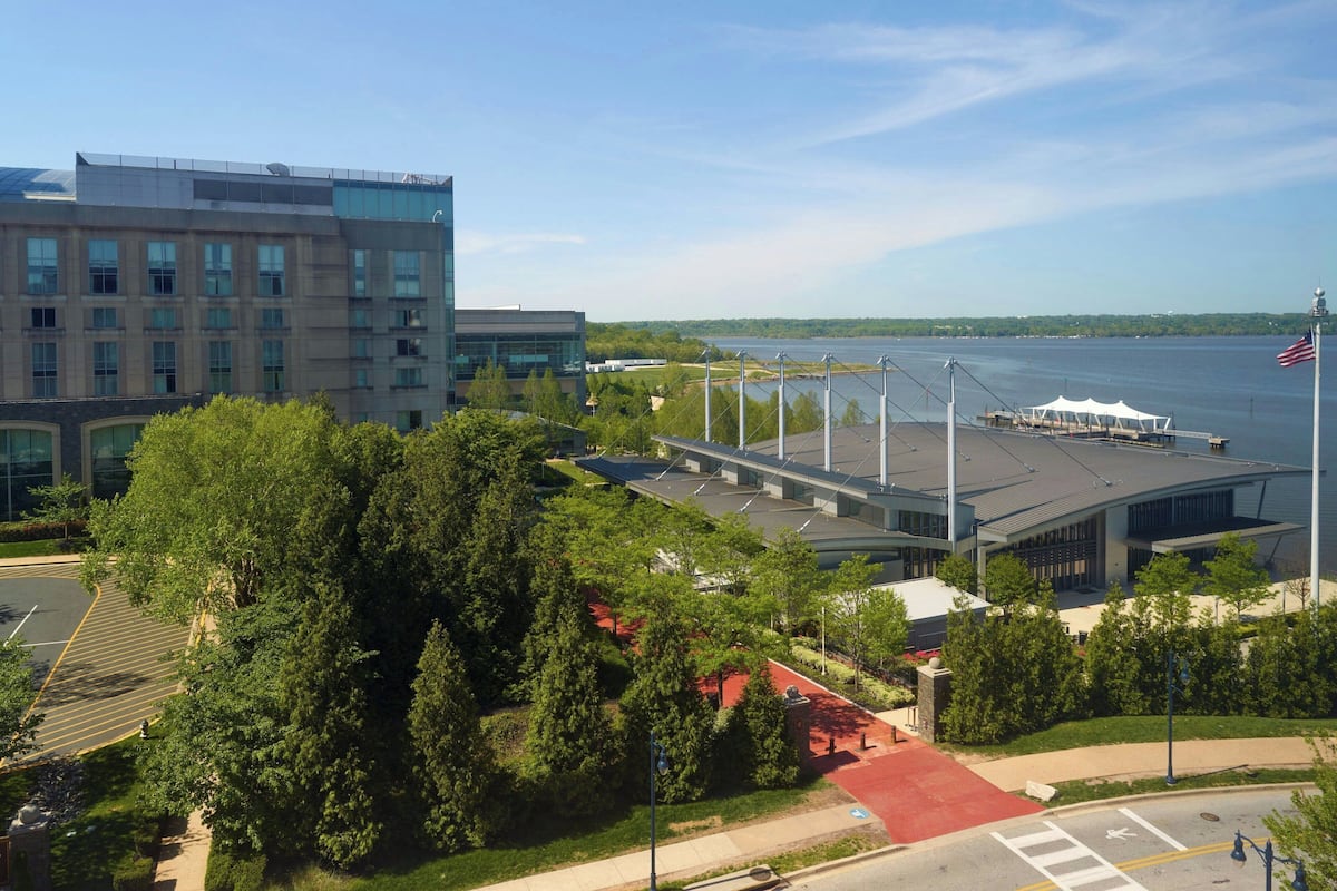 A modern building with a parking lot and a waterfront view.