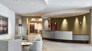 A modern lobby with a reception desk, seating area, and a patterned rug. - Residence Inn National Harbor Washington, DC Area (Oxon Hill)