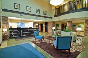 A hotel lobby with a reception desk, seating area, and a staircase. - Holiday Inn Express & Suites Oro Valley-Tucson North by IHG (Oro Valley)