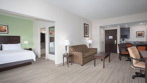 A hotel room with a bed, a sofa, a small table, a chair, and a kitchenette area. - Holiday Inn Express & Suites Oro Valley-Tucson North by IHG (Oro Valley)