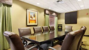 A conference room with a glass table surrounded by leather chairs, a framed painting on the wall, and a window with blinds. - Holiday Inn Express & Suites Oro Valley-Tucson North by IHG (Oro Valley)