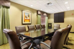 A conference room with a glass table surrounded by leather chairs, a framed painting on the wall, and a window with blinds. - Holiday Inn Express & Suites Oro Valley-Tucson North by IHG (Oro Valley)
