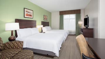 A hotel room with two beds, a desk, a chair, a television, and two lamps.