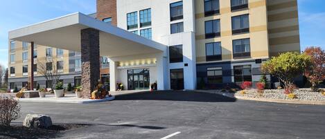 Un hôtel Fairfield by Marriott au design moderne, doté d’une entrée imposante et d’un espace paysager agrémenté de plantes en pot.