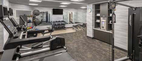 A gym with treadmills, weight machines, and free weights.