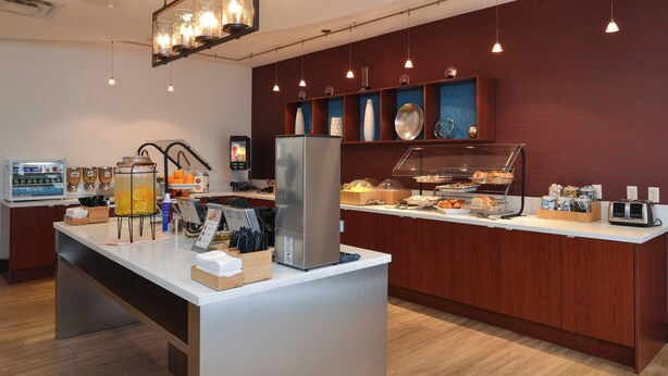 A breakfast bar with a coffee machine, fruit, and a refrigerator. - Springhill Suites by Marriott Oklahoma City Airport (Oklahoma City)
