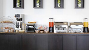 Een ontbijtbuffet met diverse etenswaren en koffieapparaten.