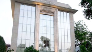 A modern building with the name 'The Sarovar Portico' prominently displayed at the top.