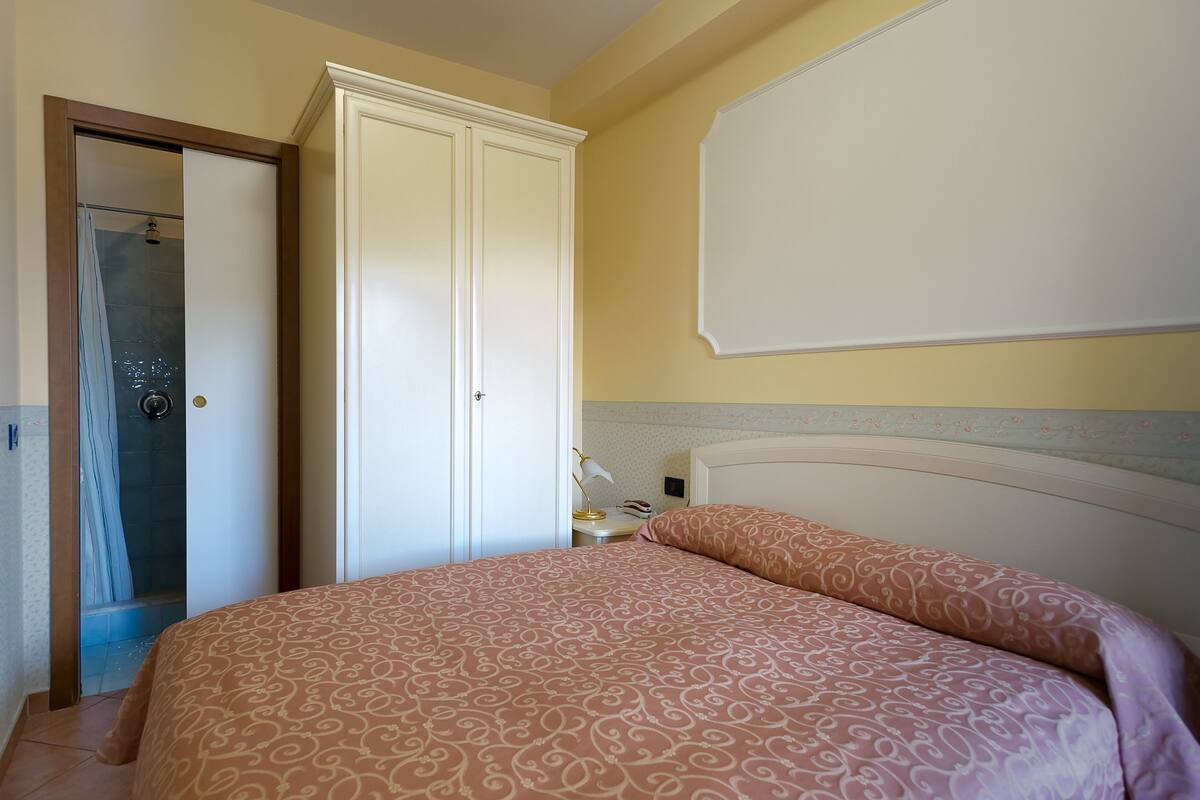 Une chambre à coucher avec un lit, une armoire et une douche.