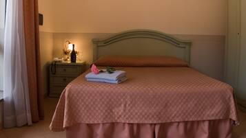 Una cama bien hecha con una colcha estampada y una almohada decorativa.