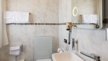 A modern bathroom with a bidet, toilet, and sink.