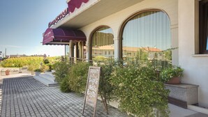 A restaurant with outdoor seating, a signboard, and a view of the surrounding area. - Park Hotel Ristorante Ca' Bianca (Istrana)