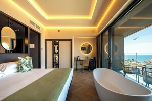 A modern hotel room with a large bed, a bathtub, a desk, and a view of the city. - Hotel Primavera Park **** Superior (Benidorm)