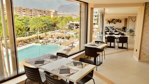 Comedor con vista a una piscina y las instalaciones del complejo.