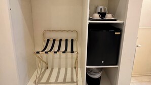 A walk-in closet with a metal rack, a hanging rack, and a black storage unit. - My Monti Place (Rome)