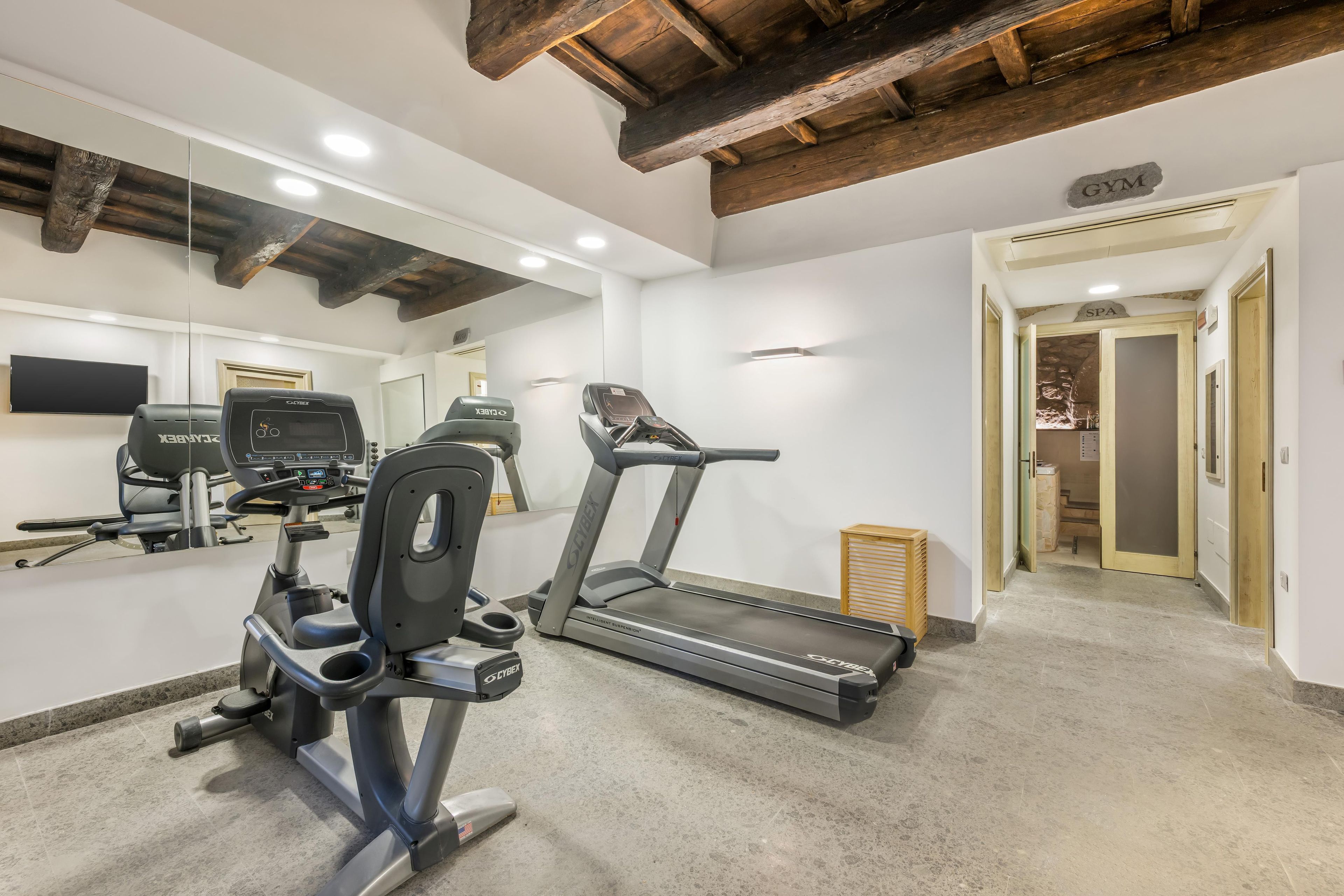 A gym with treadmills, a stationary bike, and a mirrored wall.