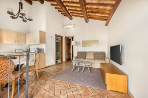 Una cocina moderna con armarios de madera, un comedor con sillas estampadas, alfombra gris y techo de madera.