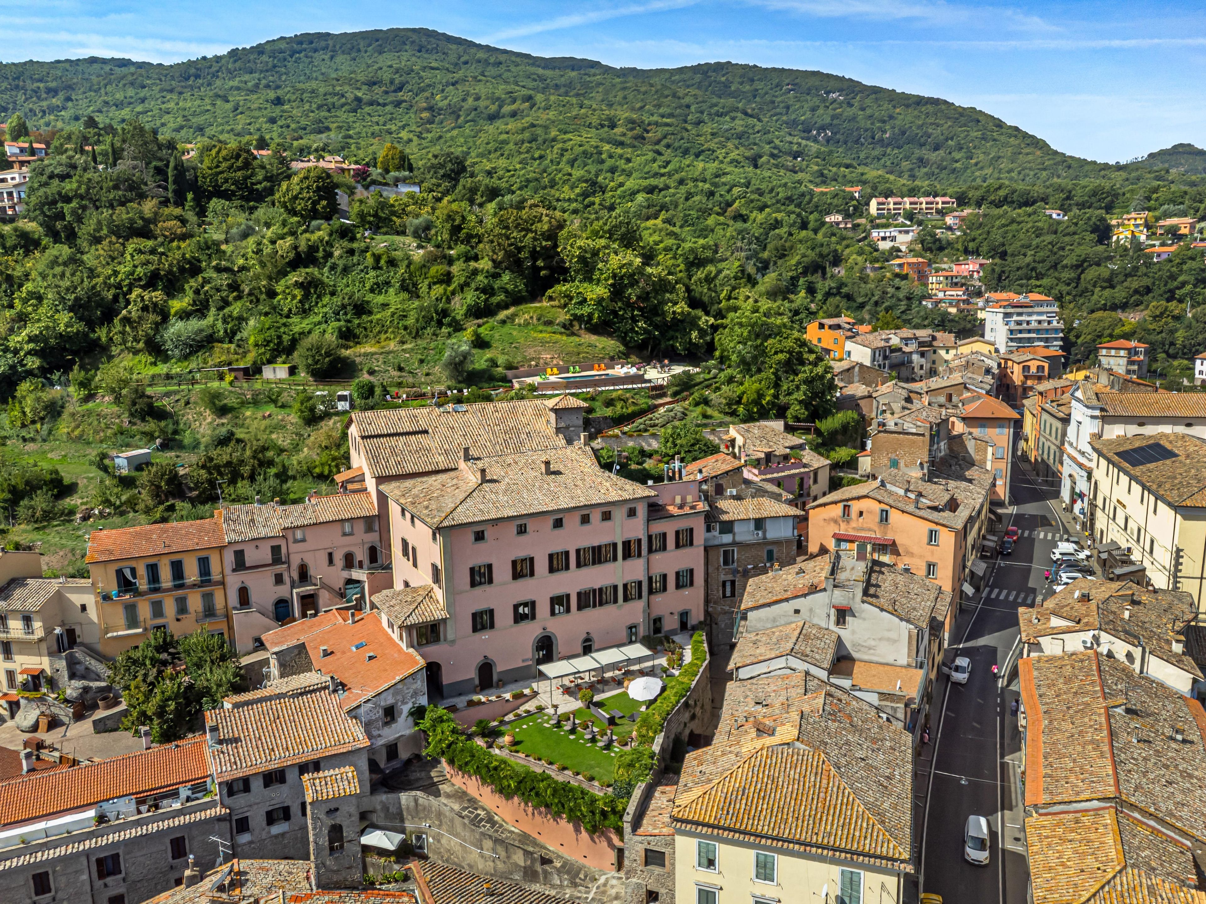 A historic town with narrow streets and traditional buildings, surrounded by lush green hills.