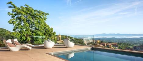 A rooftop pool area with modern seating and a view of the countryside.