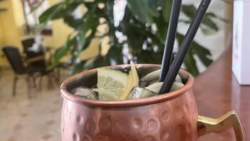 Eine kupferne Tasse mit Henkel, gefüllt mit Eiswürfeln und Limettenscheiben, steht auf einem Tisch.
