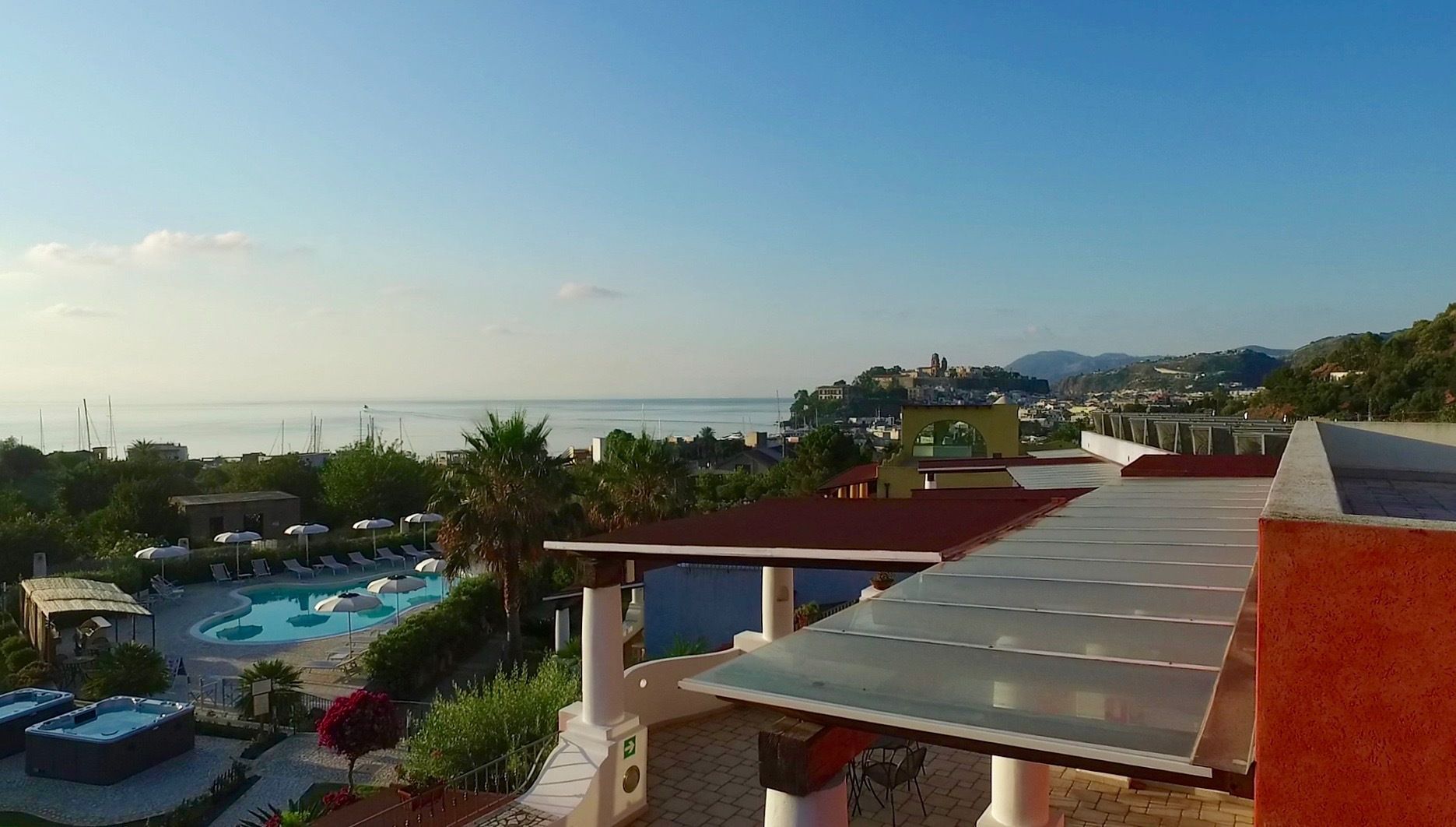 Un espace piscine aménagé sur le toit, offrant une vue sur la mer et les bâtiments environnants.