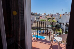 Un balcon donnant sur une piscine, avec un sol carrelé et une balustrade.