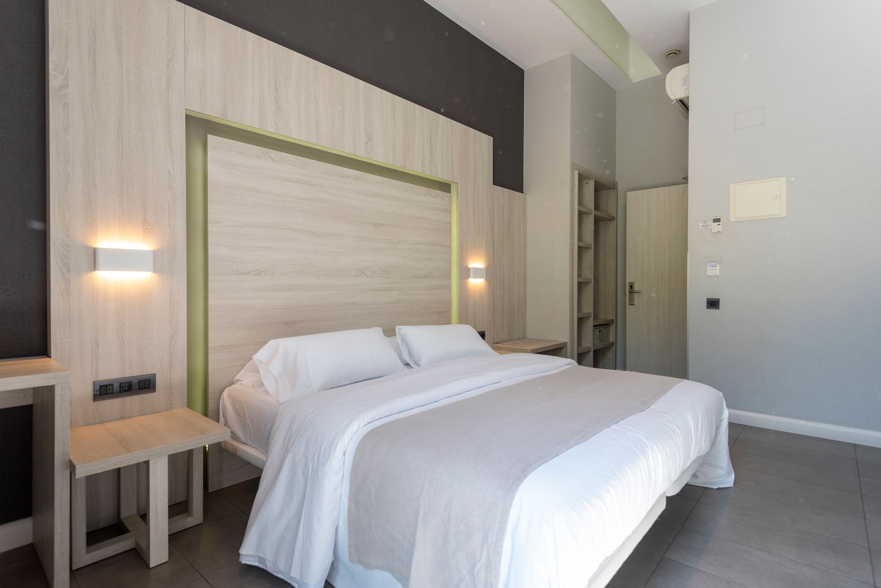 Un dormitorio moderno con una cama grande, mesitas de noche e iluminación empotrada.