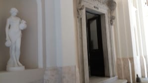 A marble statue in a hallway with a classical architectural doorway. - Residence Europa (Rome)