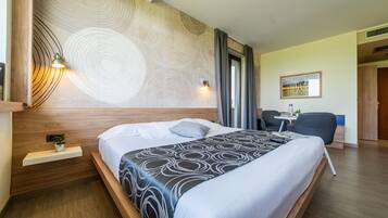 Une chambre d’hôtel moderne, dotée d’un grand lit, d’un bureau et d’une chaise.