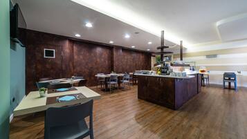 Una cucina moderna con pavimento in legno, un'isola centrale e sgabelli da bar.