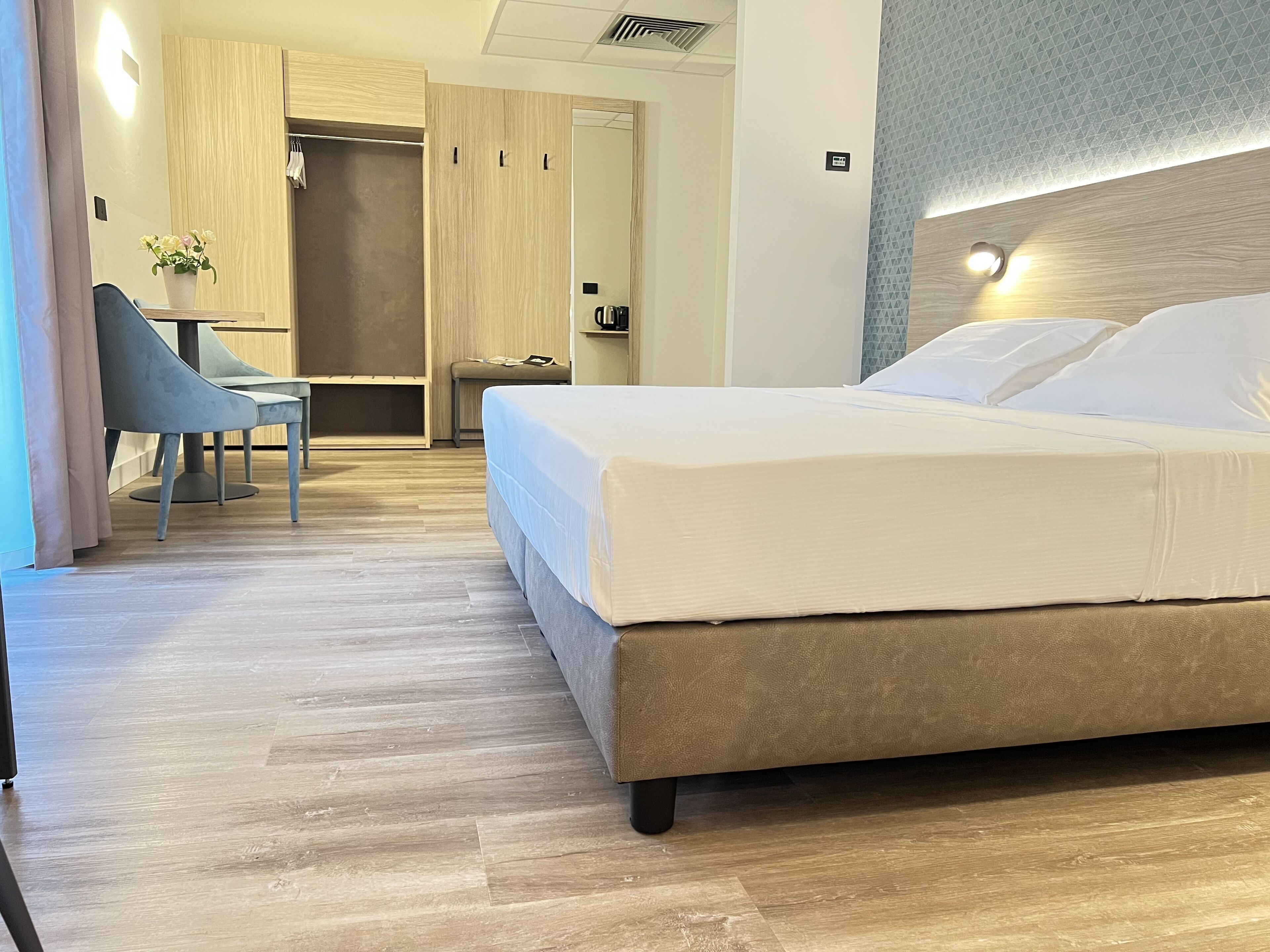 Una habitación de hotel moderna con una cama grande, un escritorio y una silla.