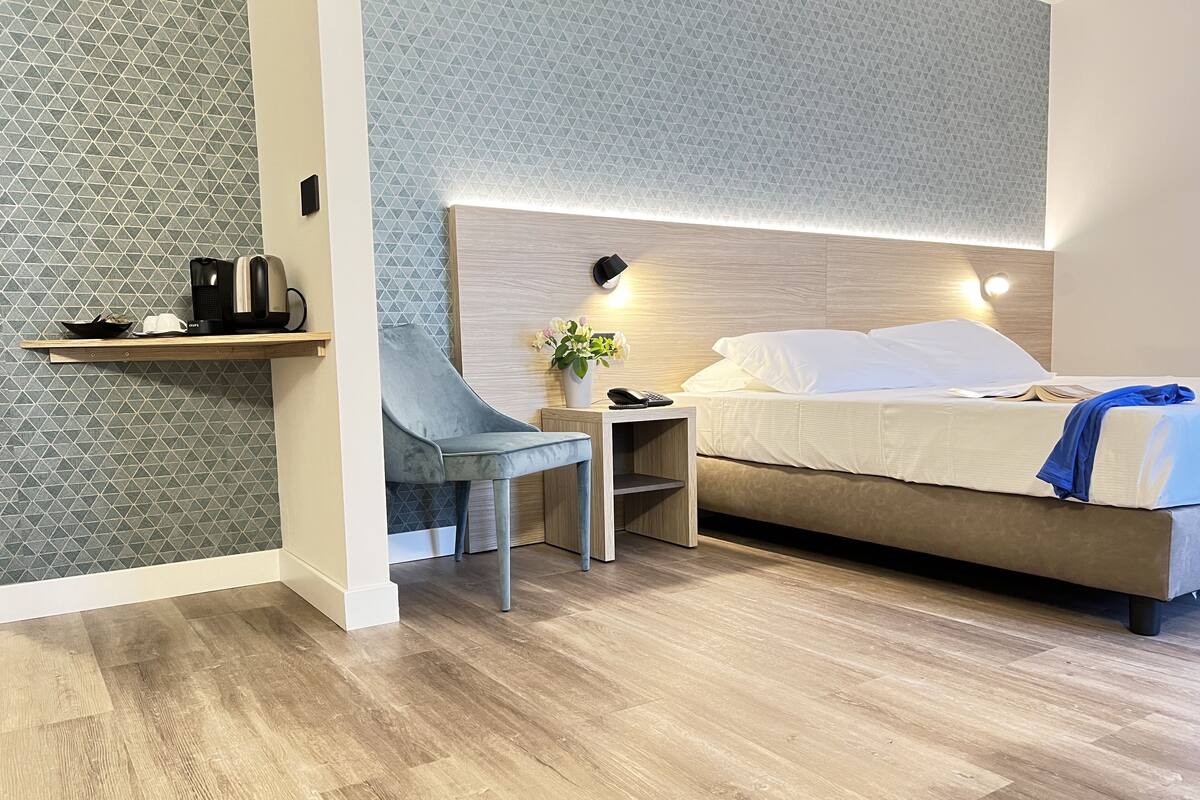 Une chambre d’hôtel moderne, équipée d’un lit, d’un bureau et d’une chaise.