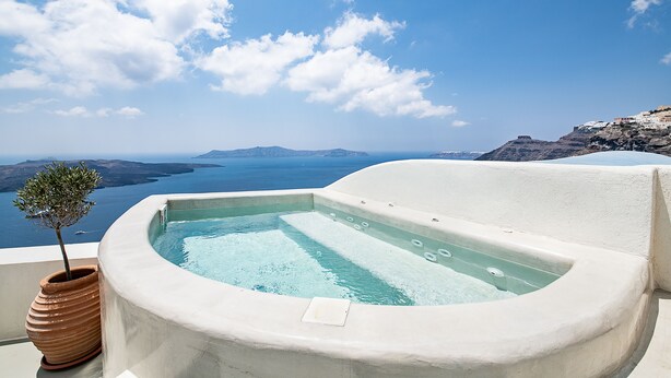 A hot tub with a view of the sea and islands. - Pantelia Suites (Santorini)